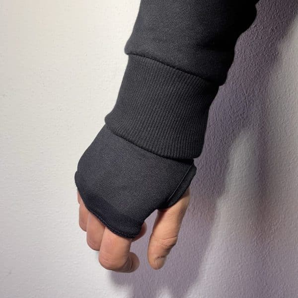 Close-up of a Second 1UP black motorcycle hoodie sleeve with thumb hole detail, enhancing comfort for motorsports riders