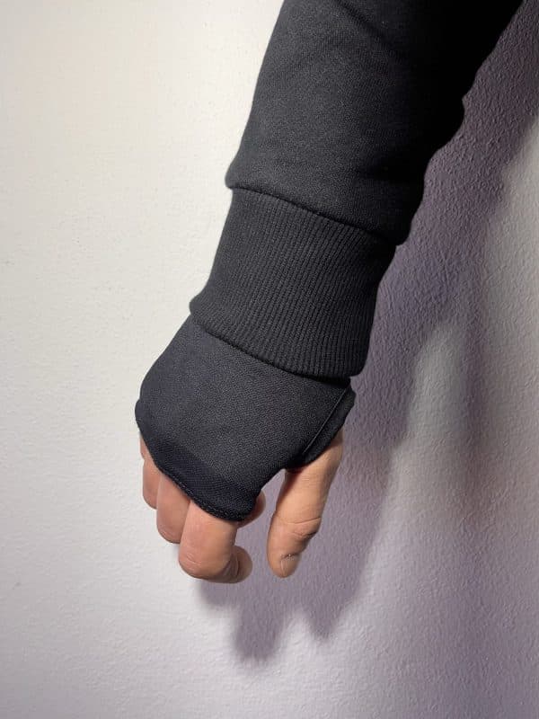 Close-up of a Second 1UP black motorcycle hoodie sleeve with thumb hole detail, enhancing comfort for motorsports riders