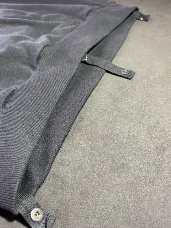 Detailed view of a Second 1UP black motorcycle hoodie with a concealed buttons for trousers, crafted for motorsports functionality