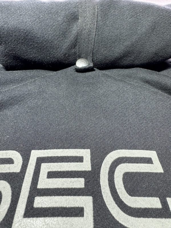 Detailed view of a Second 1UP black motorcycle hoodie with a concealed button, crafted for motorsports functionality