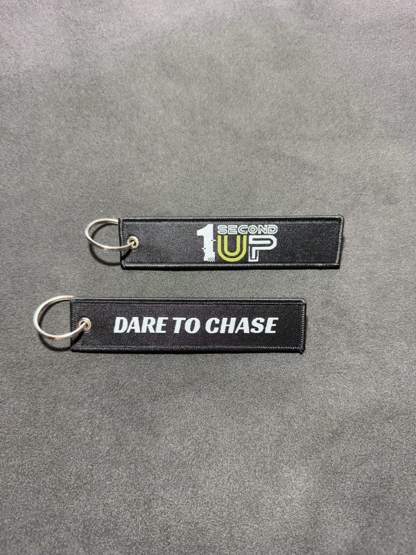 Set of black embroidered Second 1UP motorcycle keychains with 'Dare to Chase' and logo, perfect for motorsports enthusiasts