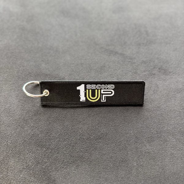 Black embroidered Second 1UP motorcycle keychain with logo, a must-have motorsports accessory