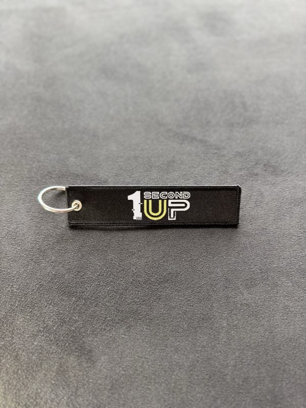 Black embroidered Second 1UP motorcycle keychain with logo, a must-have motorsports accessory
